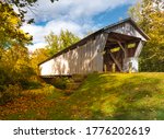 Bergstresser Dietz Covered Bridge in Canal Winchester, Ohio spanning Walnut Creek with blue sky and autumn trees