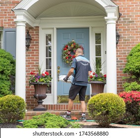 Berks County, Pennsylvania, USA, May, 21, 2020, 
Amazon Delivery Person Wearing Gloves Delivers Package To Doorstep At Suburban Home.