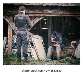 Berkshire UK March 21st 2021 - Police Officer Arrests Illegal Immigrant Suspect Found In Outbuildings Of A Remote Countryside Property.  Suspect In Handcuffs