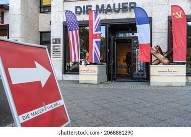 Berlin 2021: Entrance to the museum "Die Mauer" with decorative sign in the foreground with an arrow pointing in the direction of the entrance. The museum offers information about the Berlin Wall.