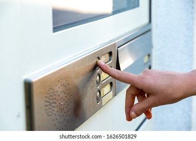 Berlin, Berlin/Germany - 03.09.2019: A Finger Pressing A Metal Front Door Bell With Several Buttons On A Front Door Where An Intercom System Is Also Installed