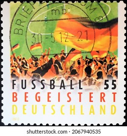 Berlin, Circa 1975: Stamp Printed In Germany Showing Crowd Waving Flag. Topics: Flags | Football | Sport.