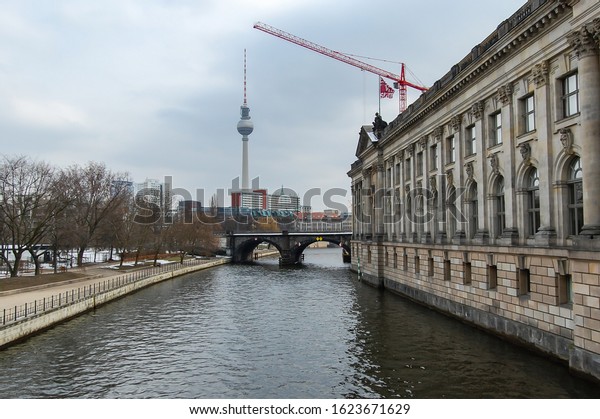 Berlin city in Germany with cars on the\
road and boats in the canals and the TV tower, Fensehturm Berlin in\
the background. Berlin, Germany March 30,\
2013.