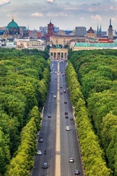 Berlin City Skyline In Germany, Aerial View Above Street Through Tiergarten Park Towards The Brandenburg Gate.