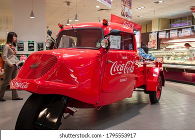 Berlin, Germany 09/14/2009: A Red Shiny Vintage Tempo Hanseat Tricycle With Coca Cola  Brand Logo Printed On It Is Put On Display In A Grocery As A Coca Cola Stand. Truck Is Full Of Cola Bottles.