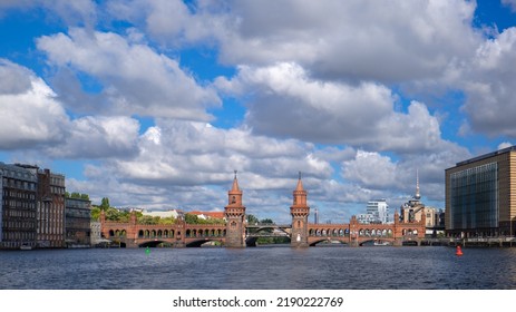 Berlin, Germany - 10.08.2022: Oberbaum Bridge (Oberbaumbrücke) On Spree River. Sunny Day, Cloudy Sky