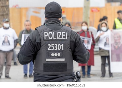 BERLIN, GERMANY APRIL 13, 2019: A German Police Officer Standing In Front Of A Group Of Protestors In Berlin During A Silent Demonstration For Abdullah Öcalan 