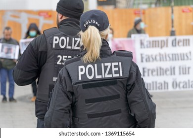 BERLIN, GERMANY APRIL 13, 2019: A German Female Police Officer Standing In Front Of A Group Of Protestors In Berlin During A Silent Demonstration For Abdullah Öcalan 