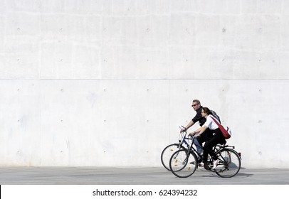 Berlin, Germany, April 25, 2006: Unidentified bicycle riders near Berlin parliament building. Bicycles are the best way to see the most Berlin interesting sites. Concrete wall background