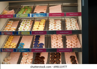 Berlin, Germany - August 13, 2017: Variety Of Dunkin' Donuts On Trays In A Display Case. Founded In 1950, Dunkin' Donuts Is An American Global Donut Company And Coffeehouse Chain