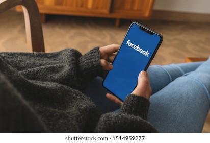 BERLIN, GERMANY AUGUST 2019:  Woman hand holding iphone Xs with logo of Facebook application in a living roo. Facebook is an online social networking service founded in February 2004 by Mark Zuckerber
