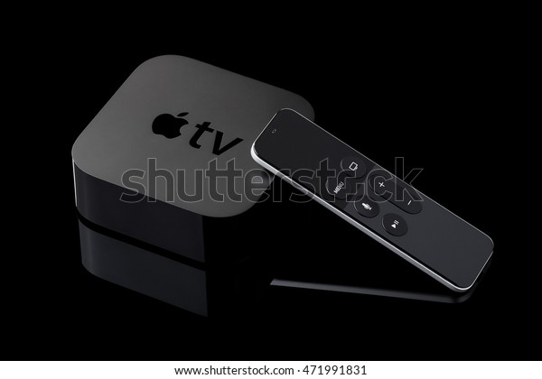 Berlin, Germany - August 21, 2016: Product shot of a fourth generation Apple TV and remote on black background.