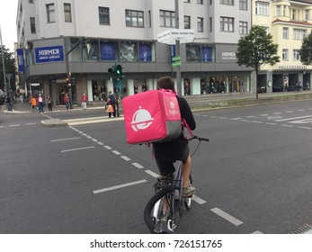 Berlin, Germany - August 24, 2017: Back Turned Foodora Delivery Man At Work On Bike. Foodora GmbH Is A Berlin-based Online Food Delivery Company