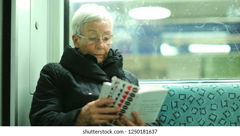 BERLIN, GERMANY, CIRCA JANUARY 2018 - Candid Authentic Real Life Of Older Woman Reading Inside Subway Train