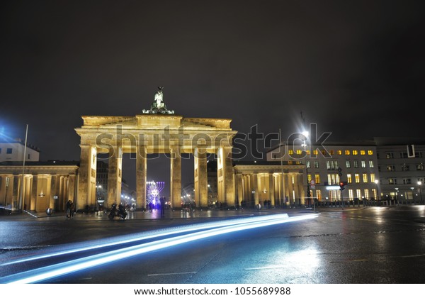 BERLIN, GERMANY -\
DECEMBER 16, 2017: Cars and the people passing by Brandenburg Gate\
on a breezy night