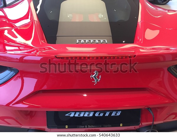 Berlin, Germany - December 19, 2016: Ferrari emblem\
on a red car. Ferrari SpA is an Italian sports car manufacturer\
based in Maranello. Founded by Enzo Ferrari, the company built\
first car in 1940