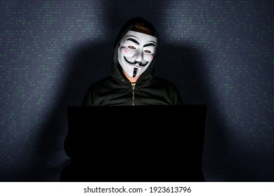 Berlin, Germany - February 23, 2021: Hacker sitting behind computer. Anonymous with Vendetta hacking. 