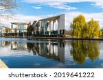 Berlin, Germany. Federal Chancellery (German: Bundeskanzleramt) with the river Spree in the foreground. View from the opposite bank of the Spree in spring in sunny weather.