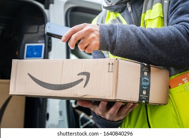 Berlin, Germany - January 27, 2020: Cropped shot of an Amazon Prime delivery agent scanning barcodes on boxes during his work shift. Amazon is an American electronic online commerce company