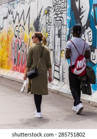 BERLIN, GERMANY July 07, 2015: A Hip Berliner Couple Walking Along The East Side Gallery At The Berlin Wall