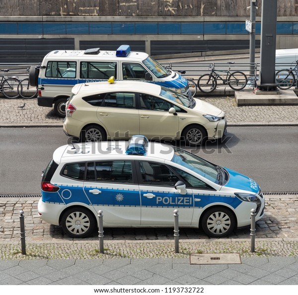 BERLIN, GERMANY - JULY 13, 2018: Berlin\
taxi and police cars parked in front of the central passenger\
railway station\
Hauptbahnhof.