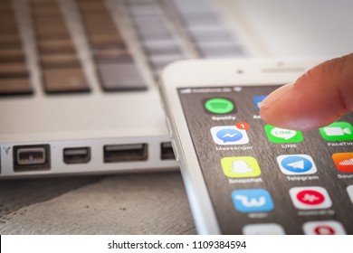 BERLIN, GERMANY - JUNE 6, 2018: Close Up To Male Finger Pressing Icon To Open Facebook Messenger App With Notification Of One Unread Message On Screen Of An IPhone 7 Plus With Personalized Background.