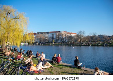 Berlin, Germany - March 30 2021: Landscape View With People Hanging Out Along Spree River In Kreuzberg 