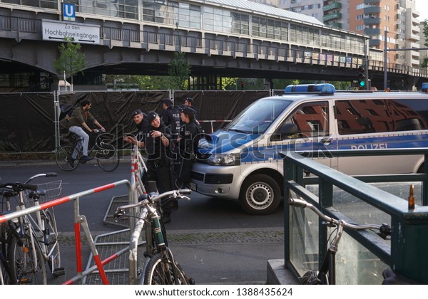 Berlin, Germany - May 1, 2019: German national police\
white and blue truck outside the Kottbusser Tor U-bahn station,\
Kreuzberg district, during the street party at May 1, International\
Workers\' Day