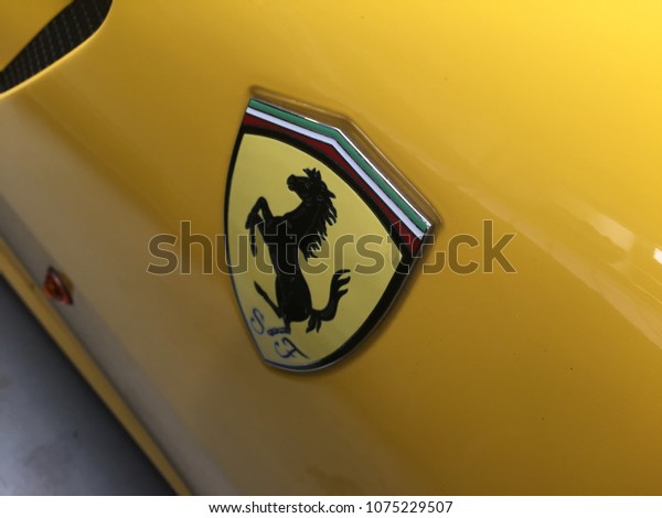 Berlin, Germany - May 13, 2017: Ferrari emblem on a\
yellow car. Ferrari SpA is an Italian sports car manufacturer based\
in Maranello. Founded by Enzo Ferrari, the company built first car\
in 1940