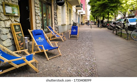 Berlin, Germany - May 15, 2020: Street With Garden Chairs From A Reopened Pub After Social Distancing Regulations Were Lessened Following The Shutdown During The Coronavirus Crisis In Germany. 