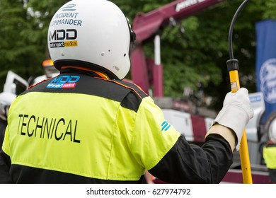 Berlin, Germany - May 20, 2016: Back Turned Technical Wearing Reflective Jacket And Full Helmet During Formula E Competition. FIA Formula E Is A Class Of Auto Racing Using Only Electric-powered Cars