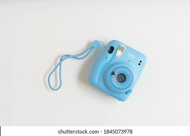 BERLIN, GERMANY- OCTOBER 30, 2020: The blue turquoise Fujifilm Instax mini 11 instant camera on background.