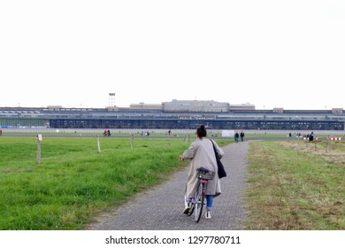 Berlin / Germany September 19 2018: A Woman Rides A Bike On A Path In The Berlin Schönefeld Airport.