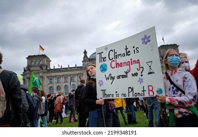 Berlin, Germany - September 24th, 2021: Two Young Female Persons Holding Up A Sign To Protest Against Climate Change Policies In Berlin In Front Of The Reichstag Building