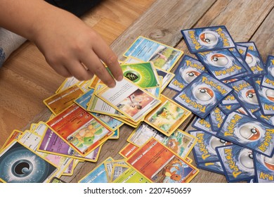 BERLIN, GERMANY - SEPTEMER 9, 2022: Boy With Pokemon Trading Cards, Collecting And Playing Game.