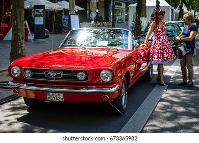 BERLIN - JUNE 17, 2017: Muscle Car Ford Mustang Convertible, 1965 And A Woman In A 60's Dress. Classic Days Berlin 2017.
