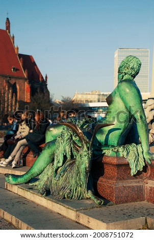 Berlin - June 2010: Mermaid of (Neptunbrunnen) Neptune fountain (1891) with Saint Marys Church in background. Sculpture: Reinhold Begas