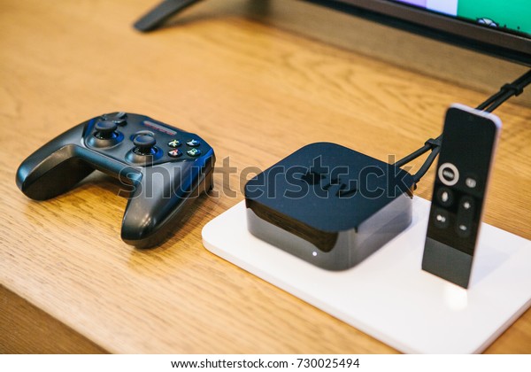 Berlin, October 2, 2017: presentation of new Apple products in the official Apple store. Modern advanced block Apple TV with a joystick and control panel lie on the table.