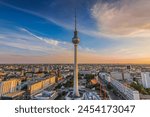 Berlin TV tower at sunset. Skyline of the capital of Germany. City center around Alexanderplatz with buildings and streets in the evening. Red Town Hall of Berlin in the background