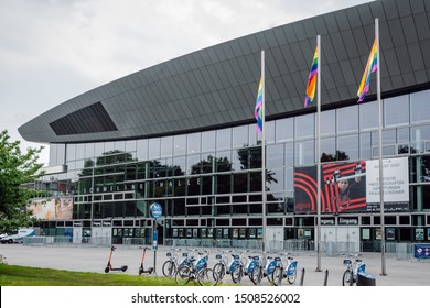 Berlin/Germany- Aug 1, 2019
View Of The Indoor Sport Arena Max Schmeling Halle, Three Pillars With Rainbow Flags And A Bicycle Rental Station In Front Of It.