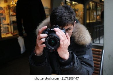 Bern, Switzerland - December 2017: A Young Man In A Winter Jacket Takes A Photo