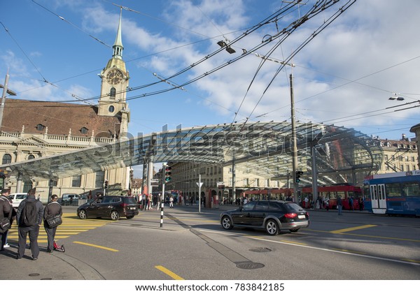 BERN, Switzerland. October 30, 2017 ; Glass roof above\
the public transport stop and several people in street of Bern,\
Switzerland.  