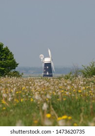 Berney Arms Windmill, Norfolk Broads In Distance Through Heat Shimmer With Wild Flower Meadow