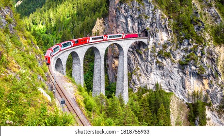 Bernina express on Landwasser Viaduct, Switzerland. It is landmark of Swiss Alps. Nice Alpine landscape in summer. Red glacier train on railroad bridge in mountains. Scenic panoramic view of railway. - Shutterstock ID 1818755933