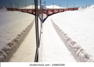 Bernina Express Train In The Snow With Its Reflection