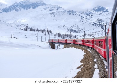 Bernina mountain pass. The famous red train is crossing the white lake. Amazing landscape of the Switzerland land. Famous destination and tourists attraction. Best of Swiss