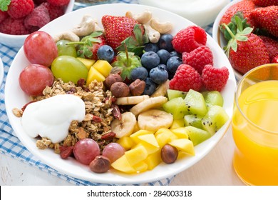 berries, fruits, nuts and granola on the plate for a healthy breakfast, close-up, top view, horizontal