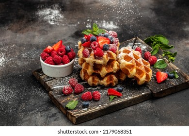 Waffle belga de Berry con frambuesas, fresas y arándanos. El concepto culinario, de cocina, de panadería. Fondo de la receta de comida. Cierra.