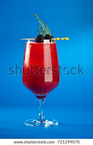 Berry Cocktails for Holiday on Blue Background. Drink Dressed with Blackberry and Thyme