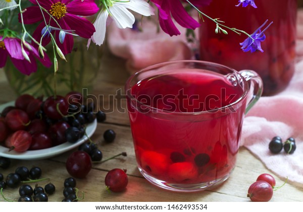 Berry compote in a\
glass cup, berries and a bouquet of wild flowers on a deoanean\
background. Rustic style.